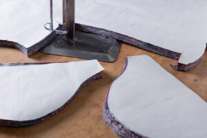 pieces of cloth and an electric knife on the table, the concept of a garment factory